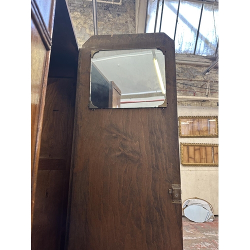 110 - An Art Deco carved oak single door wardrobe - approx. 170cm high x 74cm wide x 41cm deep