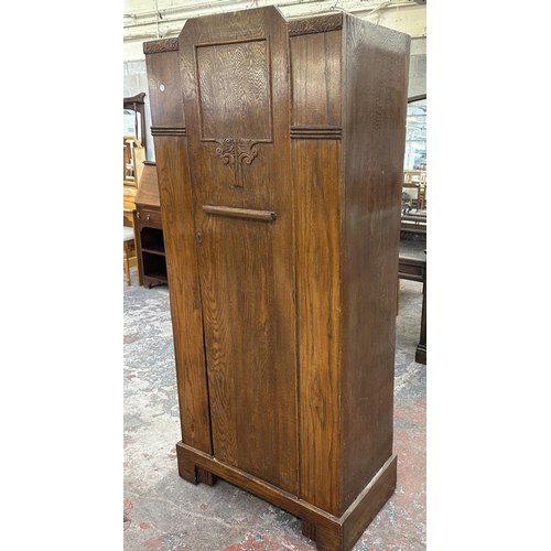 110 - An Art Deco carved oak single door wardrobe - approx. 170cm high x 74cm wide x 41cm deep