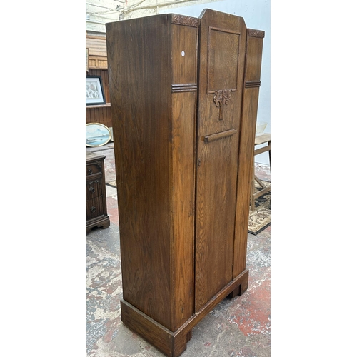 110 - An Art Deco carved oak single door wardrobe - approx. 170cm high x 74cm wide x 41cm deep