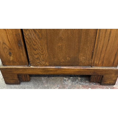 110 - An Art Deco carved oak single door wardrobe - approx. 170cm high x 74cm wide x 41cm deep