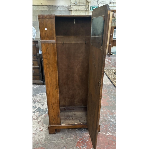 110 - An Art Deco carved oak single door wardrobe - approx. 170cm high x 74cm wide x 41cm deep