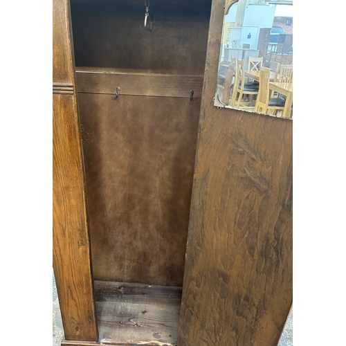 110 - An Art Deco carved oak single door wardrobe - approx. 170cm high x 74cm wide x 41cm deep