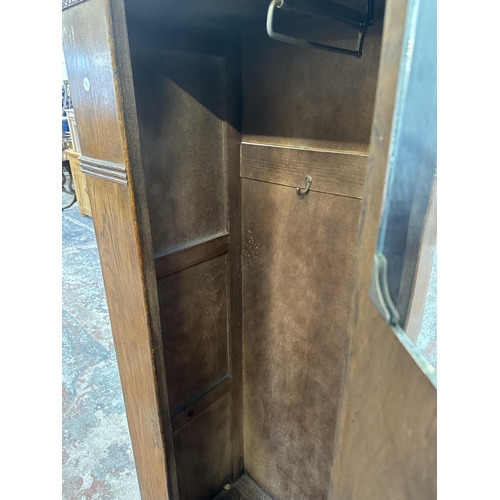 110 - An Art Deco carved oak single door wardrobe - approx. 170cm high x 74cm wide x 41cm deep