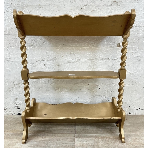 113 - An early 20th century gold painted barley twist three tier book stand - approx. 70cm high x 27cm wid... 