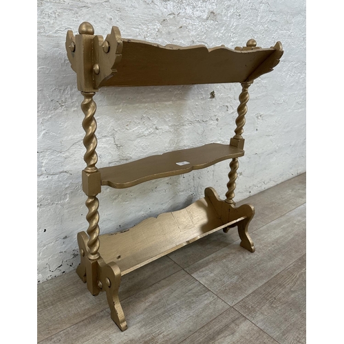 113 - An early 20th century gold painted barley twist three tier book stand - approx. 70cm high x 27cm wid... 