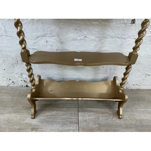 113 - An early 20th century gold painted barley twist three tier book stand - approx. 70cm high x 27cm wid... 