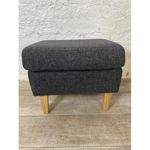 130 - A pair of IKEA grey fabric upholstered and beech armchairs with footstools