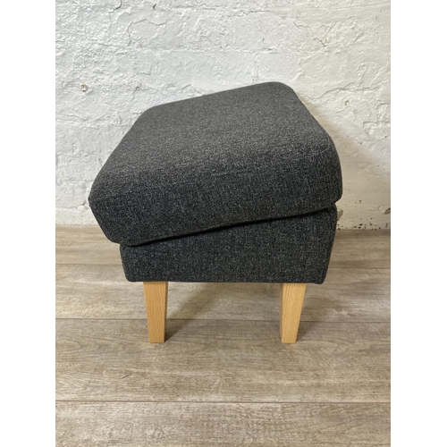 130 - A pair of IKEA grey fabric upholstered and beech armchairs with footstools