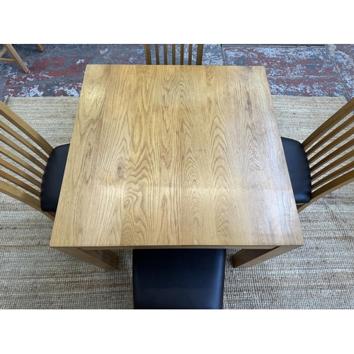 152 - A modern oak square dining table and four chairs - approx. 76cm high x 90cm square