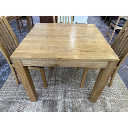 152 - A modern oak square dining table and four chairs - approx. 76cm high x 90cm square