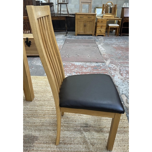 152 - A modern oak square dining table and four chairs - approx. 76cm high x 90cm square