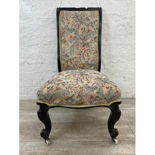 165 - A Victorian ebonised and tapestry upholstered nursing chair on castors - approx. 93cm high x 51cm wi... 