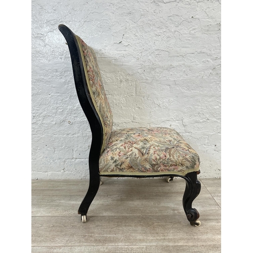 165 - A Victorian ebonised and tapestry upholstered nursing chair on castors - approx. 93cm high x 51cm wi... 