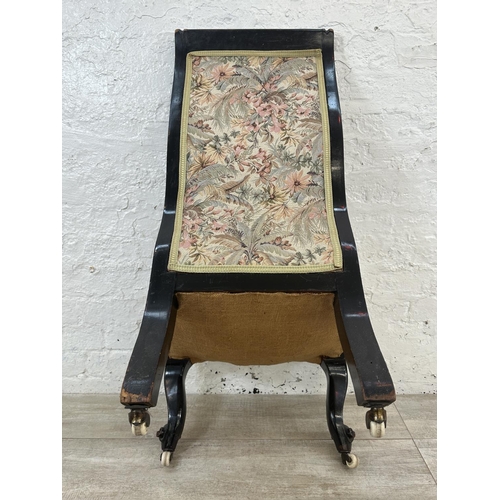 165 - A Victorian ebonised and tapestry upholstered nursing chair on castors - approx. 93cm high x 51cm wi... 