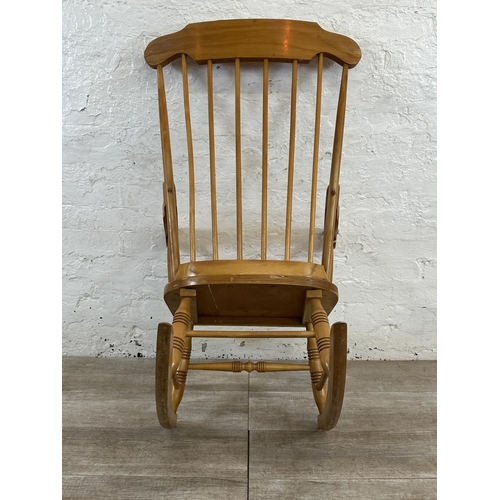 228 - A Victorian style beech spindle back farmhouse rocking chair