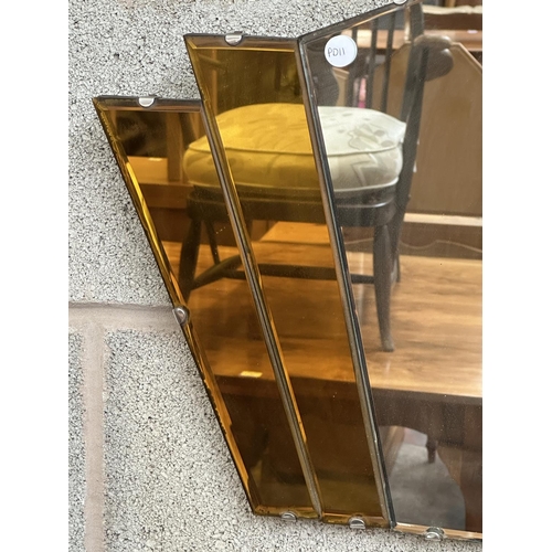 23 - An Art Deco amber glass frameless bevelled edge fan shaped wall mirror - approx. 41cm high x 69cm wi... 