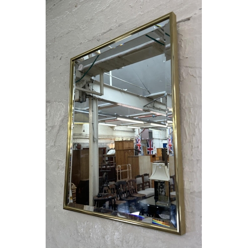 26 - A mid 20th century brass framed bevelled edge wall mirror - approx. 46cmn high x 36cm wide