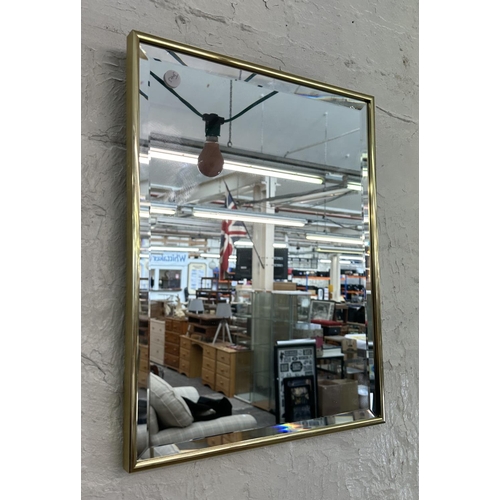 26 - A mid 20th century brass framed bevelled edge wall mirror - approx. 46cmn high x 36cm wide