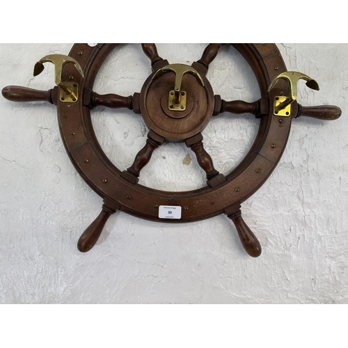 30 - A carved hardwood and brass novelty ships wheel coat rack - approx. 55cm diameter