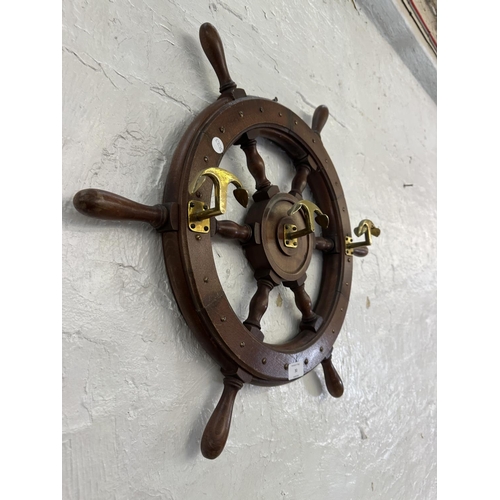 30 - A carved hardwood and brass novelty ships wheel coat rack - approx. 55cm diameter