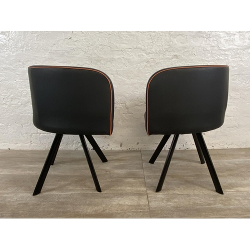 300 - A pair of modern black and orange faux leather space saving dining chairs