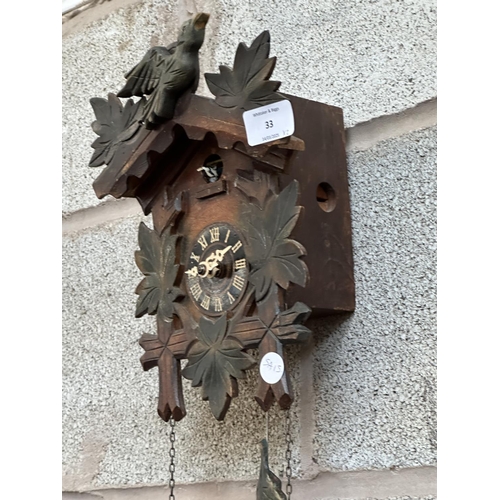 33 - Two mid 20th century Black Forest style carved wooden cuckoo clocks, both with pendulums and weights... 