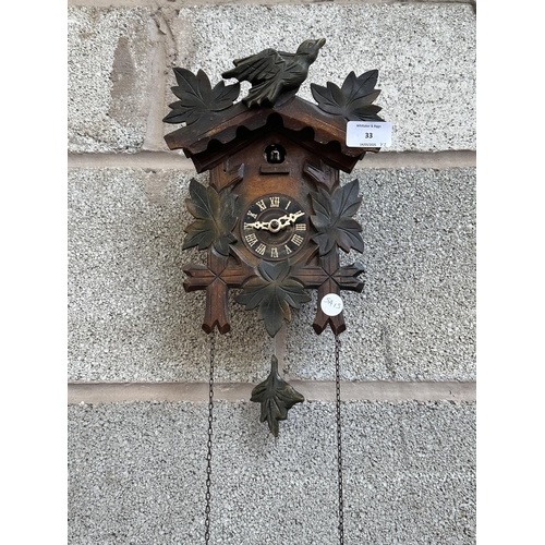 33 - Two mid 20th century Black Forest style carved wooden cuckoo clocks, both with pendulums and weights... 