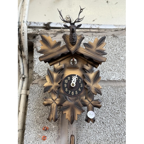 33 - Two mid 20th century Black Forest style carved wooden cuckoo clocks, both with pendulums and weights... 