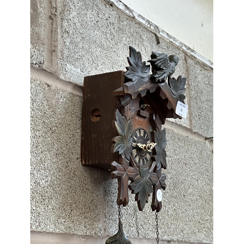 33 - Two mid 20th century Black Forest style carved wooden cuckoo clocks, both with pendulums and weights... 