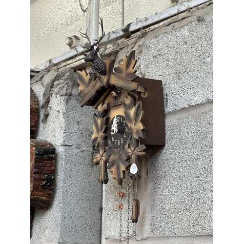 33 - Two mid 20th century Black Forest style carved wooden cuckoo clocks, both with pendulums and weights... 