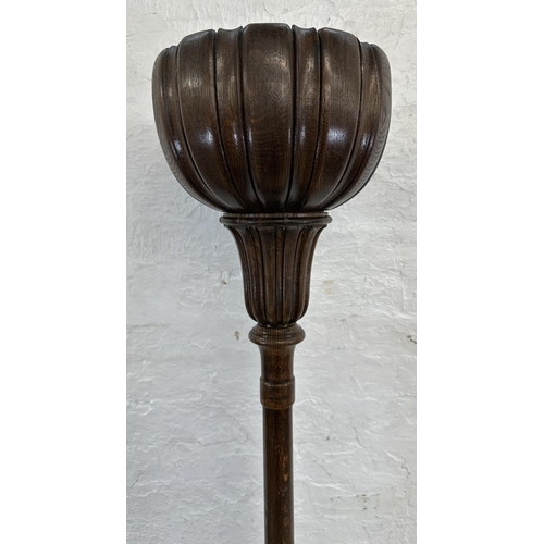 39 - A mid 20th century carved oak tulip shaped uplighter floor lamp - approx. 176cm high