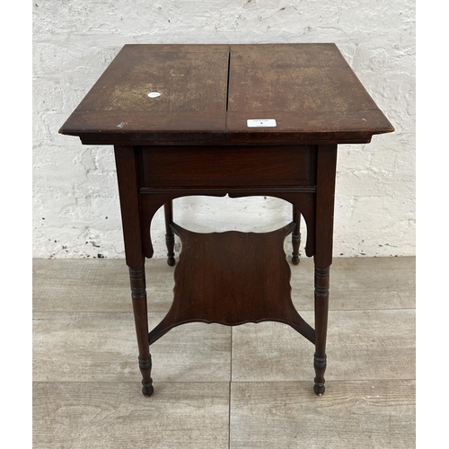 4 - An Edwardian mahogany fold over work table - approx. 66cm high x 76cm wide when extended x 38cm deep