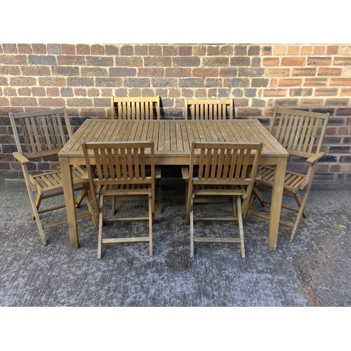 409 - A teak slatted seven piece patio set comprising rectangular table and six folding chairs - approx. 7... 