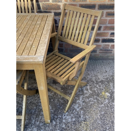 409 - A teak slatted seven piece patio set comprising rectangular table and six folding chairs - approx. 7... 