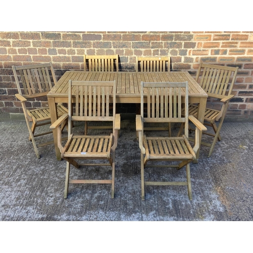 409 - A teak slatted seven piece patio set comprising rectangular table and six folding chairs - approx. 7... 