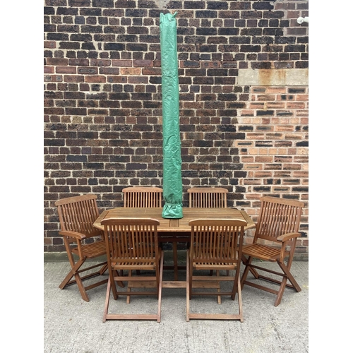 411 - A teak seven piece patio set comprising table and six folding chairs - approx. 73cm high x 78cm wide... 