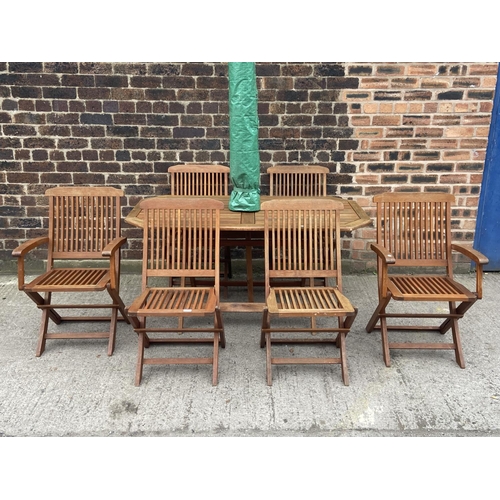 411 - A teak seven piece patio set comprising table and six folding chairs - approx. 73cm high x 78cm wide... 