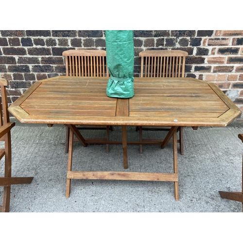 411 - A teak seven piece patio set comprising table and six folding chairs - approx. 73cm high x 78cm wide... 