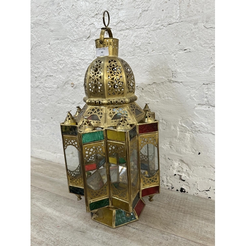 42 - A Moroccan gilt metal and stained glass hanging lantern - approx. 57cm high