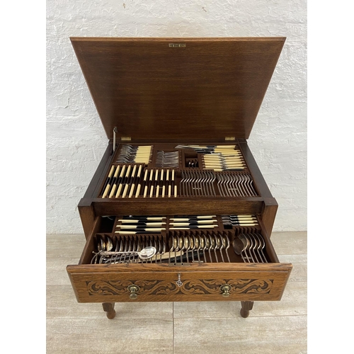 51 - A mid 20th century Jacobean style carved oak cutlery table containing EPNS cutlery - approx. 78cm hi... 