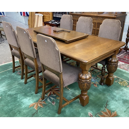 52 - A mid 20th century Jacobean style carved oak wind out dining table and six chairs with extension lea... 