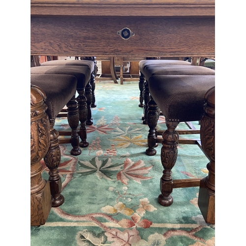 52 - A mid 20th century Jacobean style carved oak wind out dining table and six chairs with extension lea... 