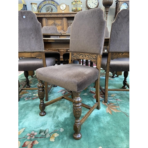 52 - A mid 20th century Jacobean style carved oak wind out dining table and six chairs with extension lea... 