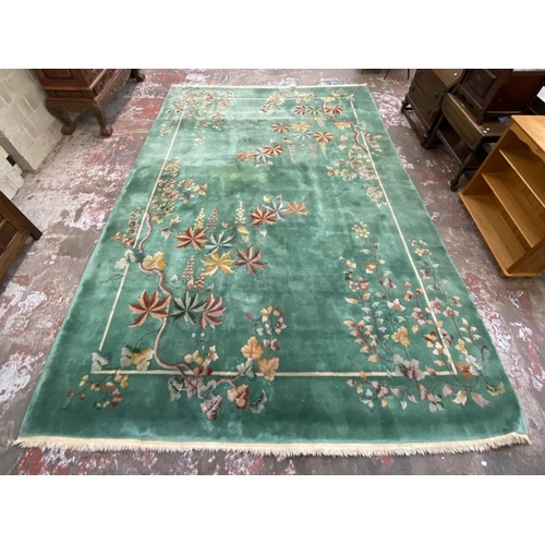 54 - A mid/late 20th century Chinese machine woven green ground floral pattern rug - approx. 395cm x 304c... 