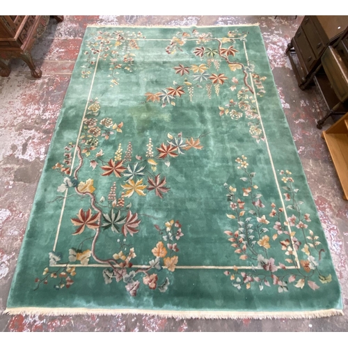 54 - A mid/late 20th century Chinese machine woven green ground floral pattern rug - approx. 395cm x 304c... 