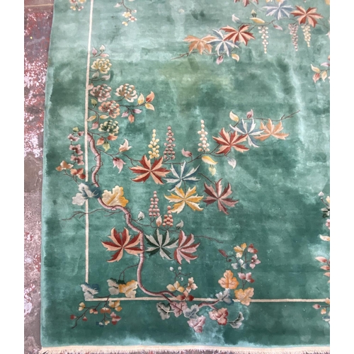 54 - A mid/late 20th century Chinese machine woven green ground floral pattern rug - approx. 395cm x 304c... 