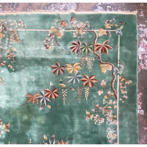 54 - A mid/late 20th century Chinese machine woven green ground floral pattern rug - approx. 395cm x 304c... 