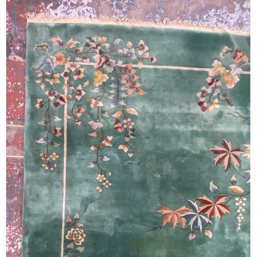 54 - A mid/late 20th century Chinese machine woven green ground floral pattern rug - approx. 395cm x 304c... 