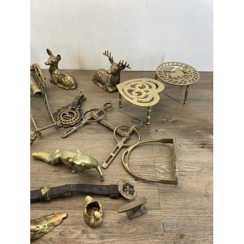 620 - A collection of brassware to include trivet stands, cannon ornament, deer figurine, pair of stirrups... 