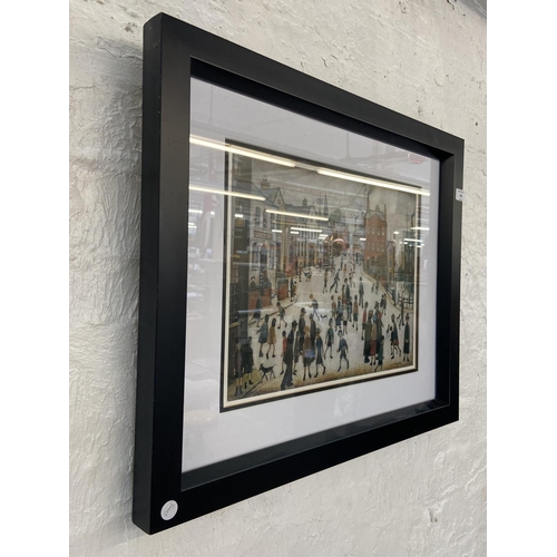 465 - A modern framed L.S Lowry print of a Manchester street scene - approx. 53cm high x 63cm wide